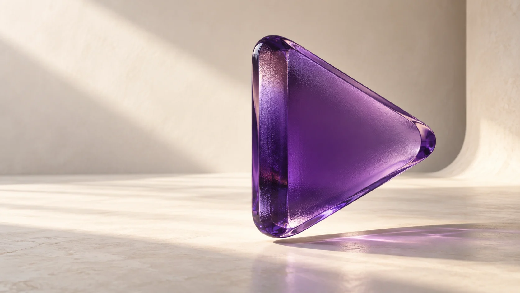 A purple glass play sculpture in a sunlit cream studio